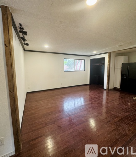 A room with wooden flooring and white walls.