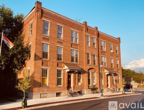 A red brick building with a flag on the left side.