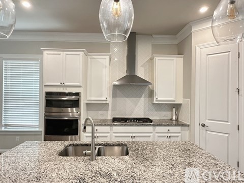 A kitchen with granite countertops and white cabinets.