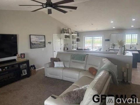 A living room with a white couch and a ceiling fan.