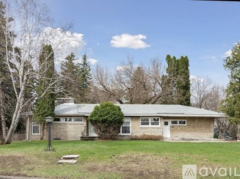 A house with a lawn in front and trees around it.