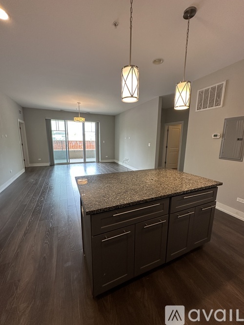 A kitchen with a granite countertop and wooden cabinets.