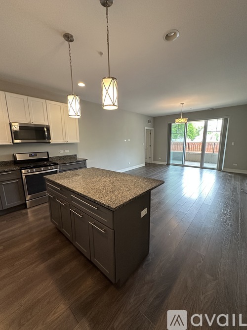 A kitchen with a granite countertop and wooden flooring.