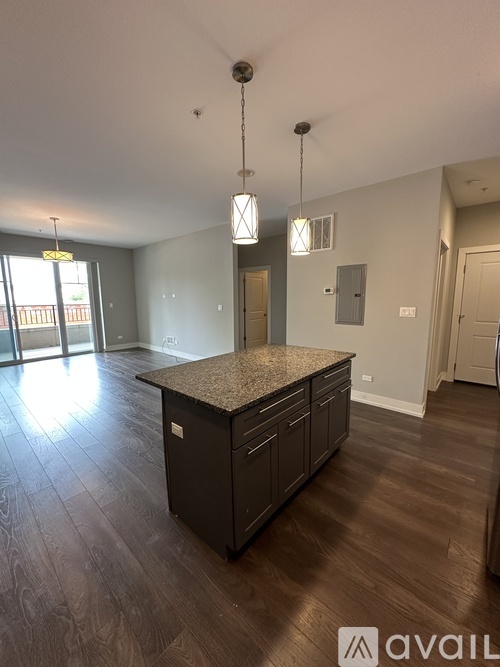A kitchen with a granite countertop and wooden flooring.