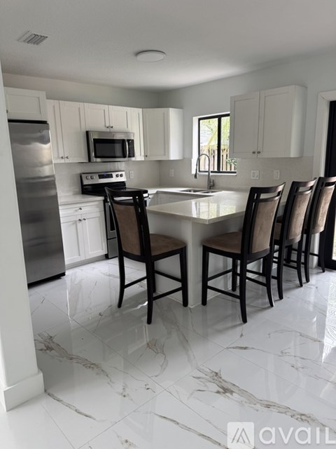A kitchen with a table and chairs.