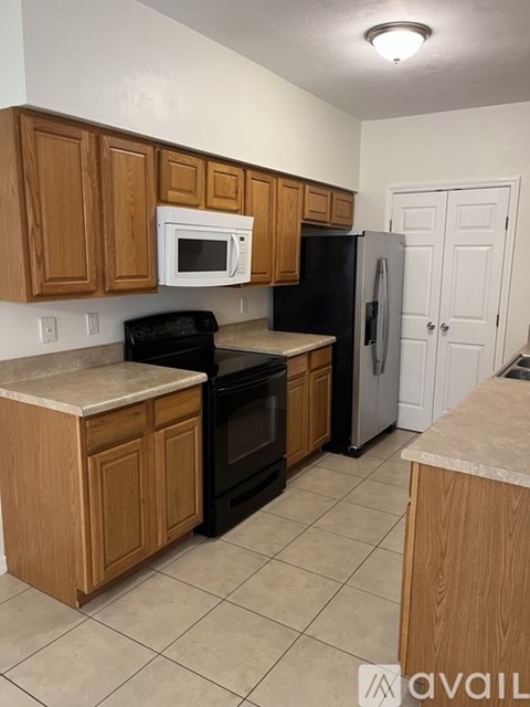 A kitchen with wooden cabinets and black appliances.