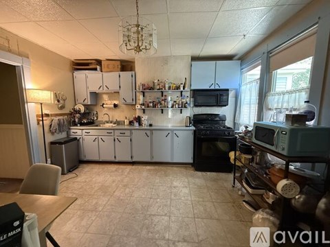 A kitchen with white cabinets and a black stove top oven.
