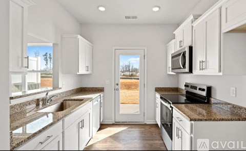 A kitchen with granite countertops and white cabinets.