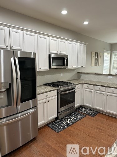 A kitchen with white cabinets and stainless steel appliances.