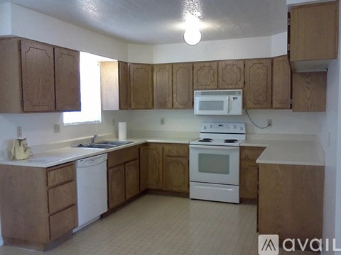 A kitchen with wooden cabinets and white appliances.
