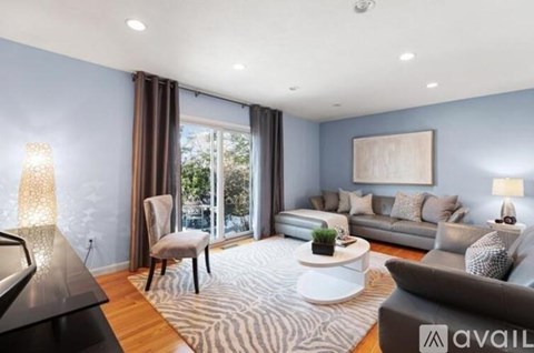 A modern living room with a grey sofa, a coffee table, and a large painting on the wall.