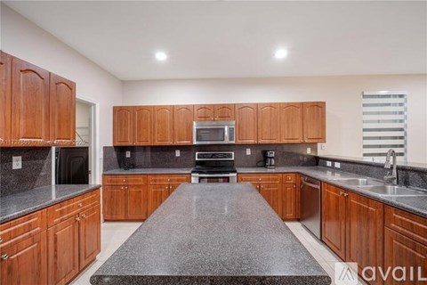 A kitchen with brown cabinets and a granite countertop.