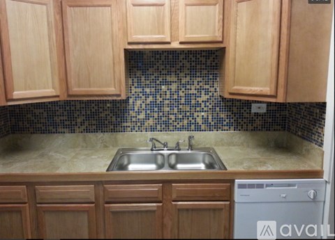 A kitchen with wooden cabinets and a tiled backsplash.