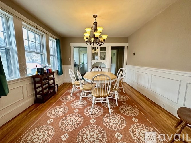 A dining room with a table and chairs.