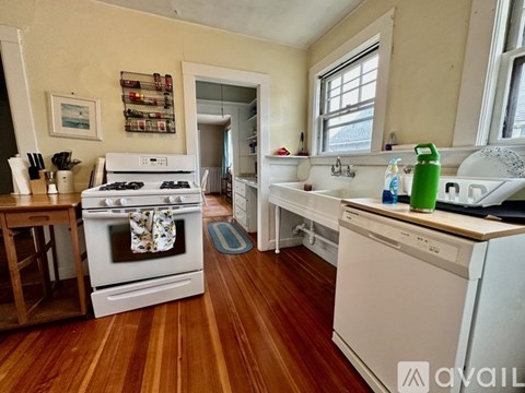 A kitchen with a white stove and a white dishwasher.