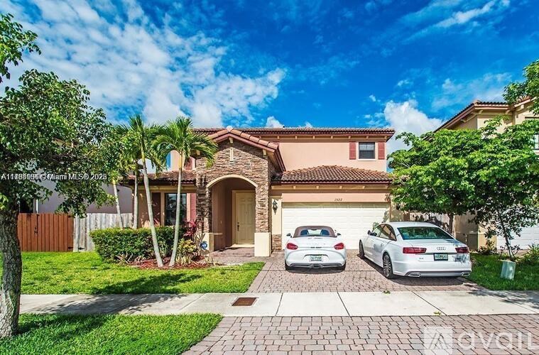A house with a red roof and two cars parked in front.