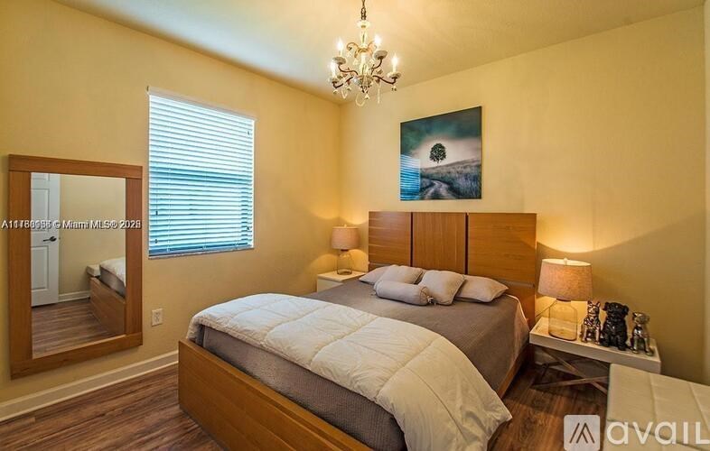 A bedroom with a large bed and a chandelier.