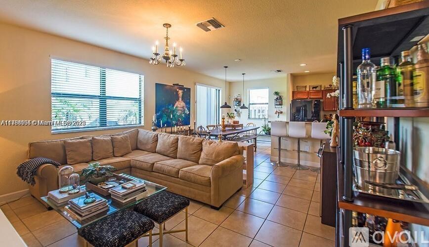 A well-lit living room with a large sofa and a bar area.