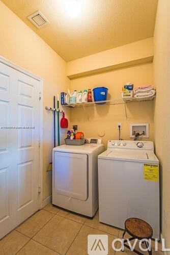A small laundry room with a washer and dryer.
