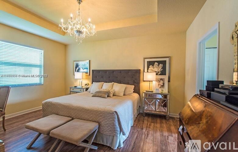 A bedroom with a large bed and a chandelier.