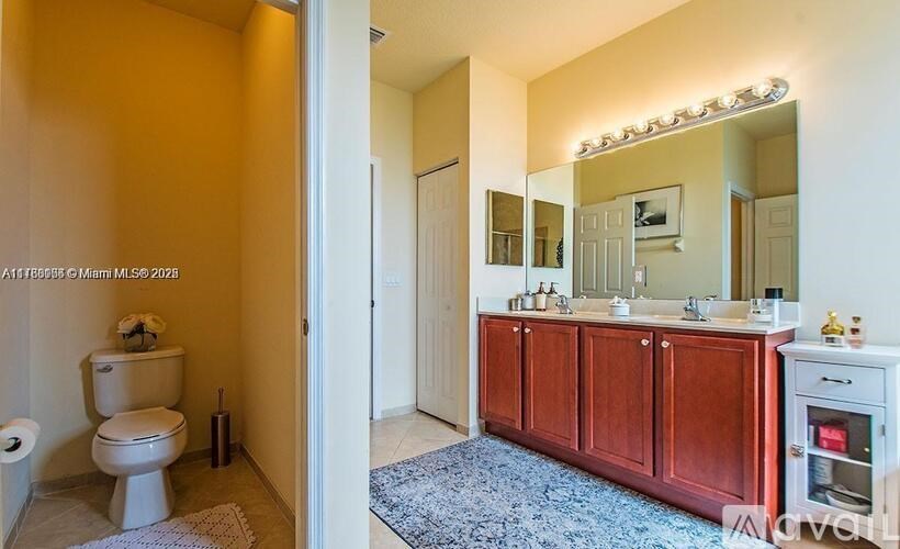 A bathroom with a toilet, sink, and mirror.