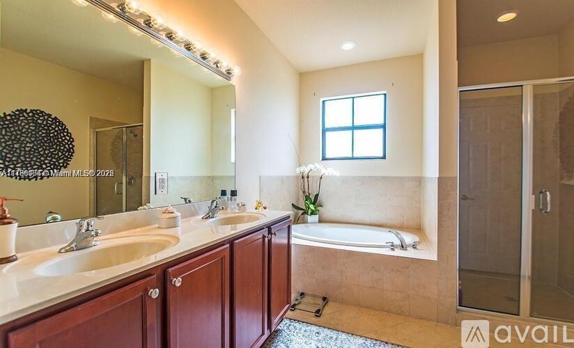 A bathroom with a large mirror, two sinks, and a bathtub.
