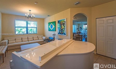 A living room with a large couch and a piano.