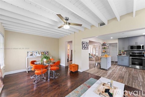 A living room with a dining table and chairs.