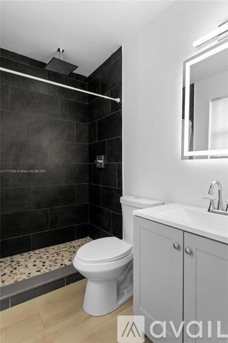 A bathroom with a toilet, sink, and mirror.