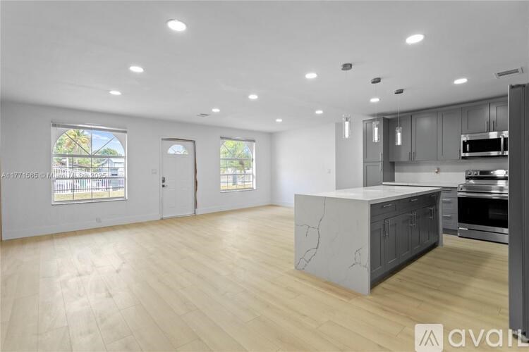 A spacious kitchen with wooden floors and a large island.