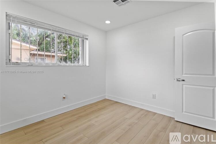 A room with a window and a door is available for rent.