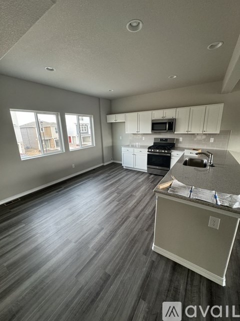A spacious kitchen and living room with wood flooring and a large island.