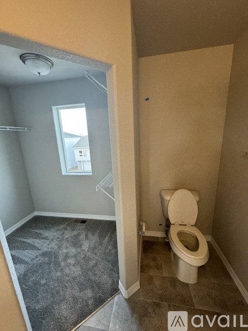 A bathroom with a toilet and a window.