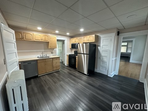 A kitchen with wooden floors and white walls.