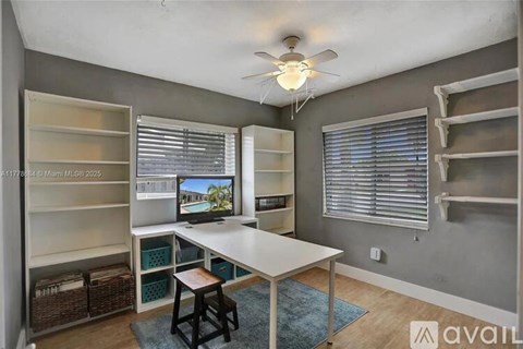 A room with a desk, chairs, and shelves.