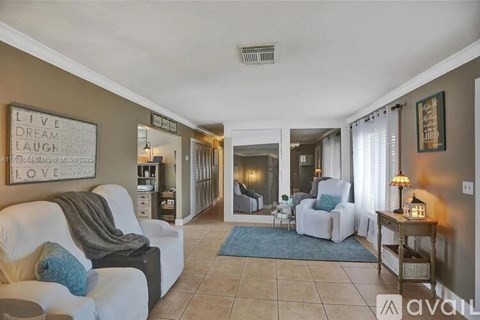 A living room with a white couch and a sign that says "Live Dream Love".
