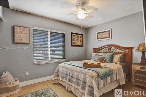 A bedroom with a bed, a ceiling fan, and a window with blinds.