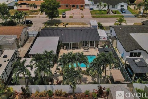 A house with a pool surrounded by palm trees.