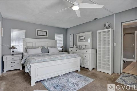 A bedroom with a bed, dresser, and nightstand.