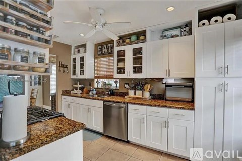 A kitchen with granite countertops and white cabinets.