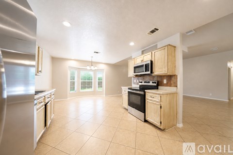 A kitchen with wooden cabinets and appliances is available for rent.