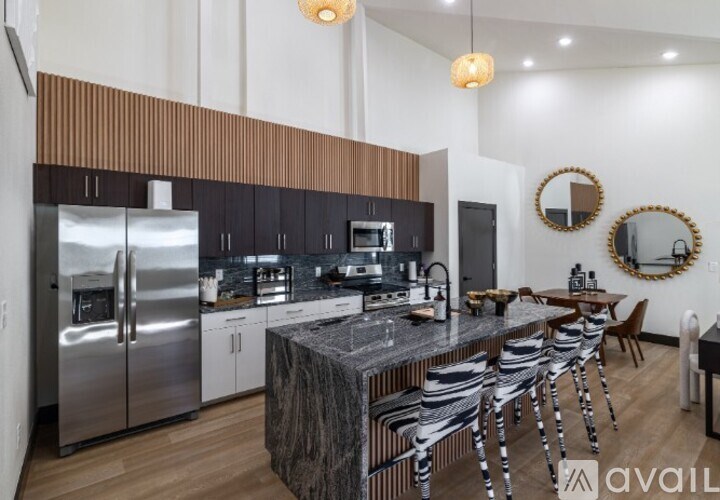 A modern kitchen with a marble island and stainless steel appliances.