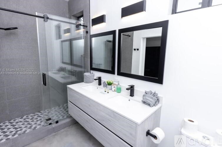 A modern bathroom with a white sink and a glass shower.