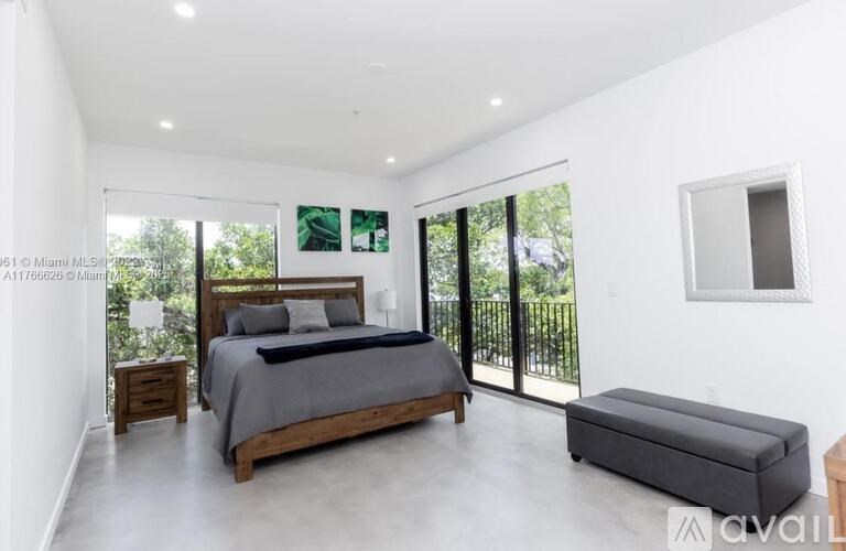 A bedroom with a large bed and a bench.