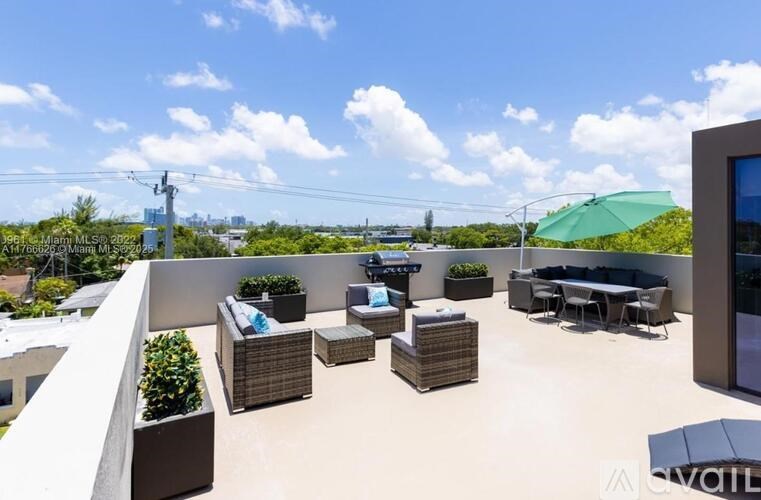 A rooftop patio with furniture and a view of the city.