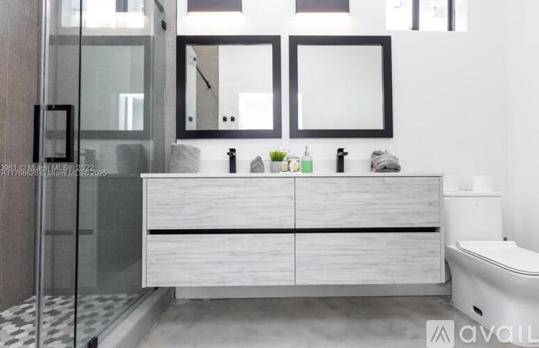 A modern bathroom with a glass shower door and a white cabinet.