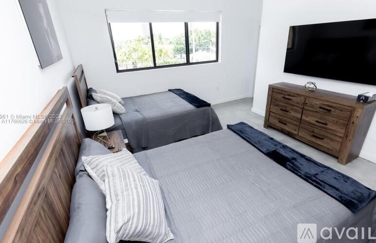 A bedroom with a bed, a dresser, and a television.