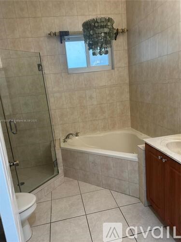 A bathroom with a tub, toilet, and sink.