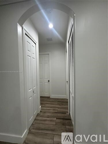 A hallway with white doors and a light on the ceiling.