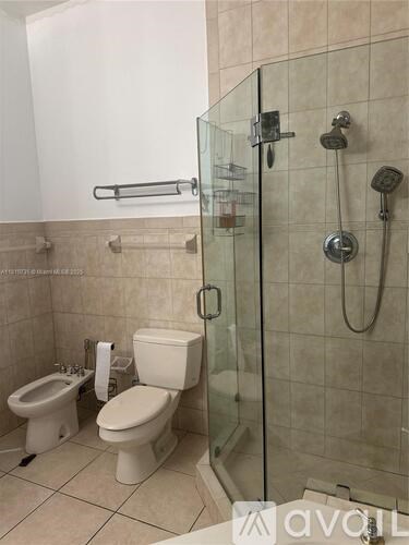 A bathroom with a toilet, sink, and shower.